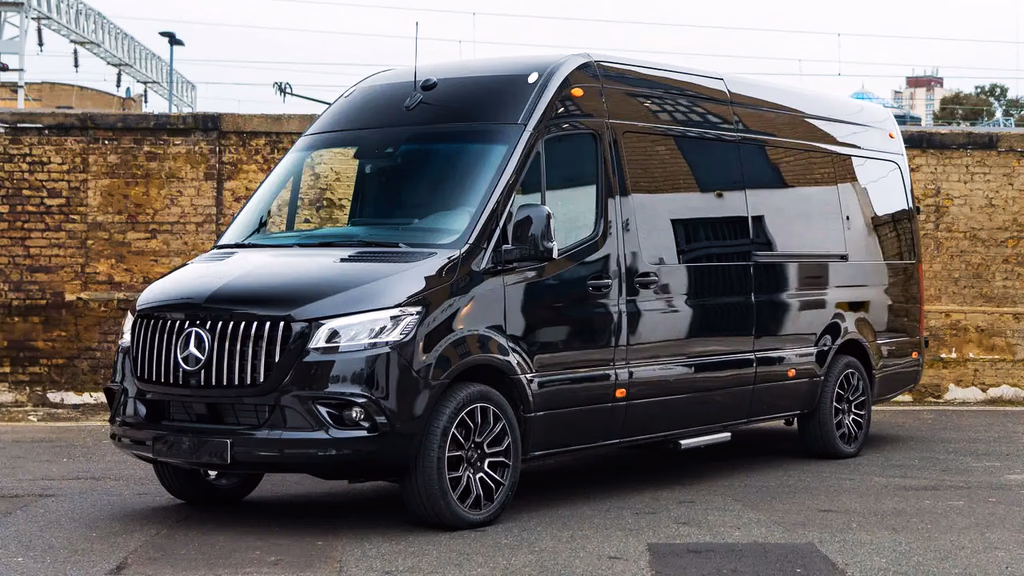 Black Mercedes-Benz Sprinter van parked in front of a brick wall